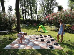 two girls playing with a chessboard in a park at Hotel Playa Blanca in Duna Verde
