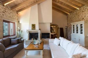 a living room with a white couch and a fireplace at Villa Stimpolis in Argyroupolis
