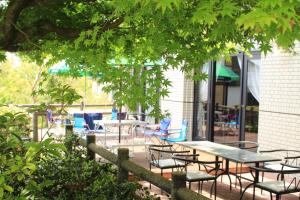 a group of tables and chairs under a tree at Reposer makino in Takashima