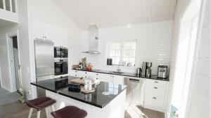 a white kitchen with a black counter top at Jarvso House. Ski In / Ski Out. in Järvsö