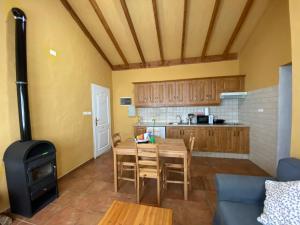 uma cozinha com uma mesa de madeira e um fogão em Breñoso 2 em Puntagorda