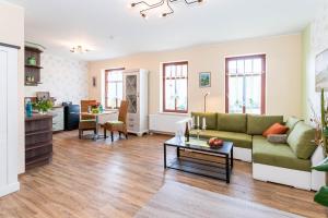 a living room with a couch and a table at Weingut Pawis Appartements in Freyburg