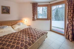 a bedroom with a bed and a large window at Chalet Hinterstein in Scheffau am Wilden Kaiser