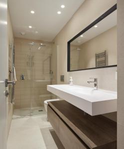 uma casa de banho com um lavatório branco e um chuveiro em Kimu - Basque Stay em San Sebastián