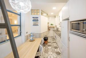 BetiJai - Basque Stay في سان سيباستيان: مطبخ مع طاولة خشبية في الغرفة