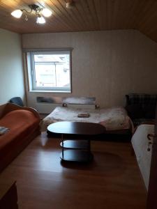 a room with two beds and a table and a window at Ginto nakvynės namai in Vilnius