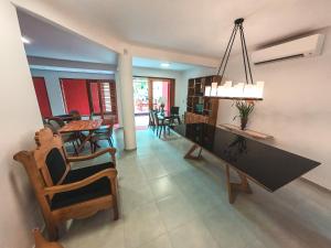 a dining room and living room with a table and chairs at Amarilis Pousada Arraial d'Ajuda in Arraial d'Ajuda