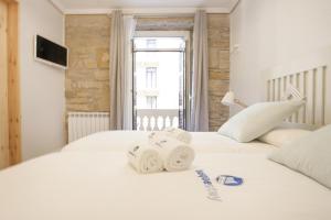 2 weiße Betten in einem Zimmer mit Fenster in der Unterkunft Gerezi - Basque Stay in San Sebastián