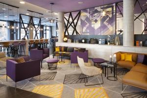 美因河畔法兰克福Holiday Inn - the niu, Air Frankfurt Messe by IHG的一个带沙发和桌子的大堂和一间酒吧