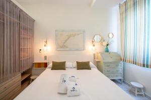 a bedroom with a large white bed and a dresser at BetiJai - Basque Stay in San Sebastián