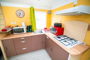 a small kitchen with a stove and a microwave at La ferme de Piardiere in Plessé