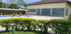 a house with a swimming pool and two chairs at Cananeia Residencial in Cananéia