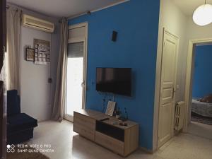 a living room with a blue wall with a television at Apartment Tunis 1 Near airport in Ariana