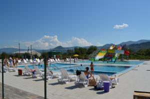 a pool with a bunch of people sitting in lawn chairs at Tulipan Hotel Aquapark in Vyshkove