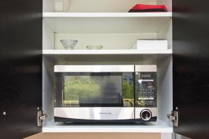 a microwave on a shelf in a kitchen at Apartament Słoneczne Południe in Gdańsk