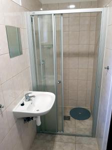 ein Bad mit einem Waschbecken und einer Dusche in der Unterkunft Autocamp Slunce Žandov in Žandov