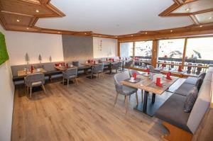 a restaurant with tables and chairs and windows at Hotel Garni Bergblick in Biberach bei Offenburg