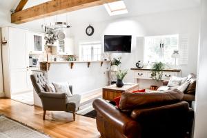 uma sala de estar com um sofá e cadeiras em Chichester Cottage em Funtington