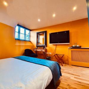 a bedroom with a bed and a television at The Old Lodge in Stroud