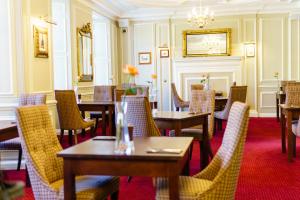 a dining room with tables and chairs and a chandelier at Bedford Hotel in Tavistock