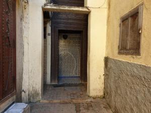 una entrada a un edificio con puerta de madera en Riad Dar Senhaji en Fez