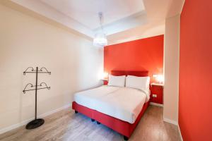 a bed in a room with an orange wall at Residence Lenno in Lenno