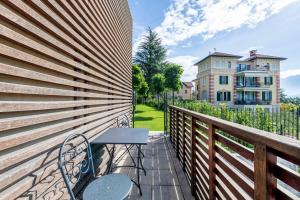 a balcony with a table and chairs on a fence at Residence Lenno in Lenno