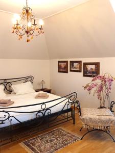 1 dormitorio con cama y lámpara de araña en Penzion a Restauracia Toldi, en Galanta