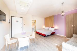een kamer met een bed, een tafel en stoelen bij Residence Lenno in Lenno +34 foto's
