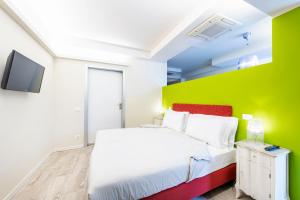 a bedroom with a white bed and a green wall at Residence Lenno in Lenno