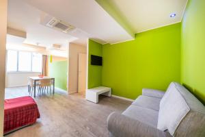 a living room with green walls and a couch at Residence Lenno in Lenno