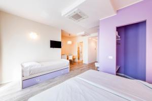 a bedroom with two beds with purple walls at Residence Lenno in Lenno