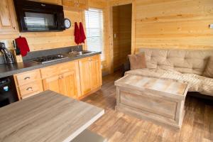 a living room with a couch and a kitchen at Westport Inn Cabins in Westport