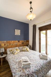 um quarto com uma cama e uma parede azul em La posada del Cani em Cómpeta