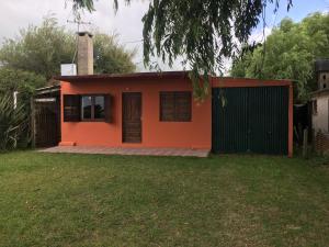 een klein oranje huis met een zwarte poort bij Pancho Villa in Barra de Valizas