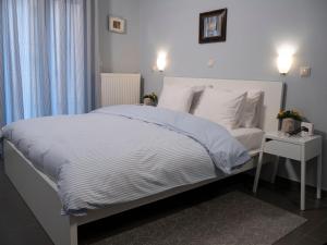 1 dormitorio con cama blanca y mesita de noche en Central Terrace Modern Apartment, en Tesalónica