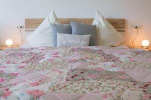 a large bed with a quilt and pillows on it at Haus Strandburg Seebriese in Dahme