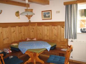 um quarto com uma mesa de madeira, uma mesa e cadeiras em Ferienhaus Margotti em Altaussee