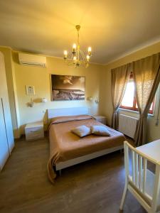 a bedroom with a large bed and a chandelier at La Dolce Sosta in Campagnano di Roma