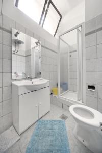 a bathroom with a sink and a toilet and a shower at Apartments Rosso in Hvar