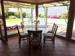 a dining room with a table and chairs and a pool at Luxusvilla ***** in Cavriana, Tessin in Magadino