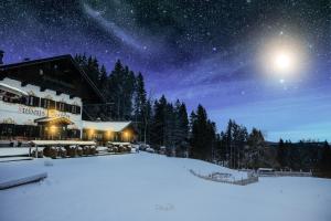 un hotel en la nieve bajo un cielo estrellado en Freihaus Brenner, en Bad Wiessee