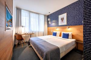 a hotel room with a large bed and a desk at Roombach Hotel Budapest Center in Budapest