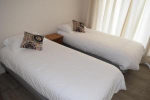 twee bedden naast een raam in een kamer bij Pura Vida - nuevo apartamento con salida directa a la costa in Concón