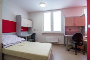 a bedroom with a bed and a desk and two chairs at Dom Studenta AŁ in Łomża +35 photos