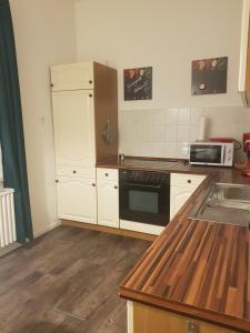 a kitchen with white cabinets and a black stove top oven at Ferienwohnung Peters in Bad Harzburg