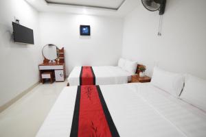 a hotel room with two beds and a television at Asean Garden Homestay Hue in Hue