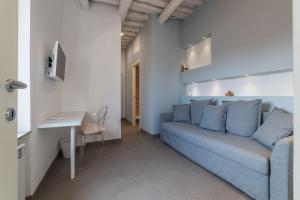 a living room with a blue couch and a table at Piazza Navona Panoramic Penthouse in Rome