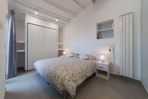 a white bedroom with a bed and two lamps on a night stand at Piazza Navona Panoramic Penthouse in Rome