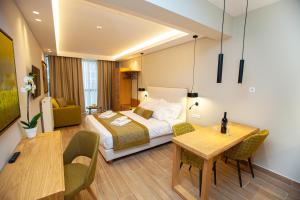 Habitación de hotel con cama, mesa y sillas en No21 Luxury Suites, en Tesalónica
